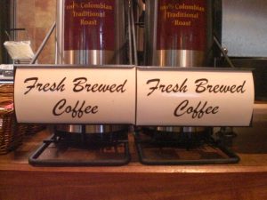 Fresh Brewed Coffee Dispensers Two stainless steel coffee dispensers labeled "Fresh Brewed Coffee," offering 100% Colombian Traditional Roast.