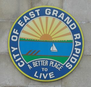 City of East Grand Rapids Emblem A circular emblem for the City of East Grand Rapids, featuring a scenic design with a rising sun, sailboat, and the slogan "A Better Place to Live."