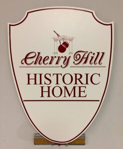 Cherry Hill Historic Home Sign A white shield-shaped sign with burgundy text and border reading "Cherry Hill Historic Home," featuring a cherry and architectural motif.