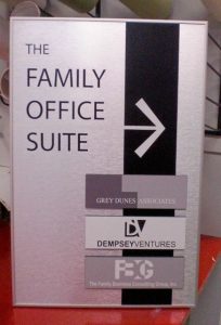 The Family Office Suite Sign A silver office sign for "The Family Office Suite," featuring directional guidance and company names including Grey Dunes Associates, Dempsey Ventures, and The Family Business Consulting Group, Inc.