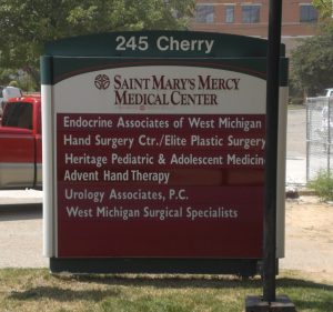 Saint Mary's Mercy Medical Center Directory Sign A business directory sign for Saint Mary's Mercy Medical Center at 245 Cherry, listing medical specialties such as endocrinology, plastic surgery, pediatrics, hand therapy, urology, and surgical specialists.
